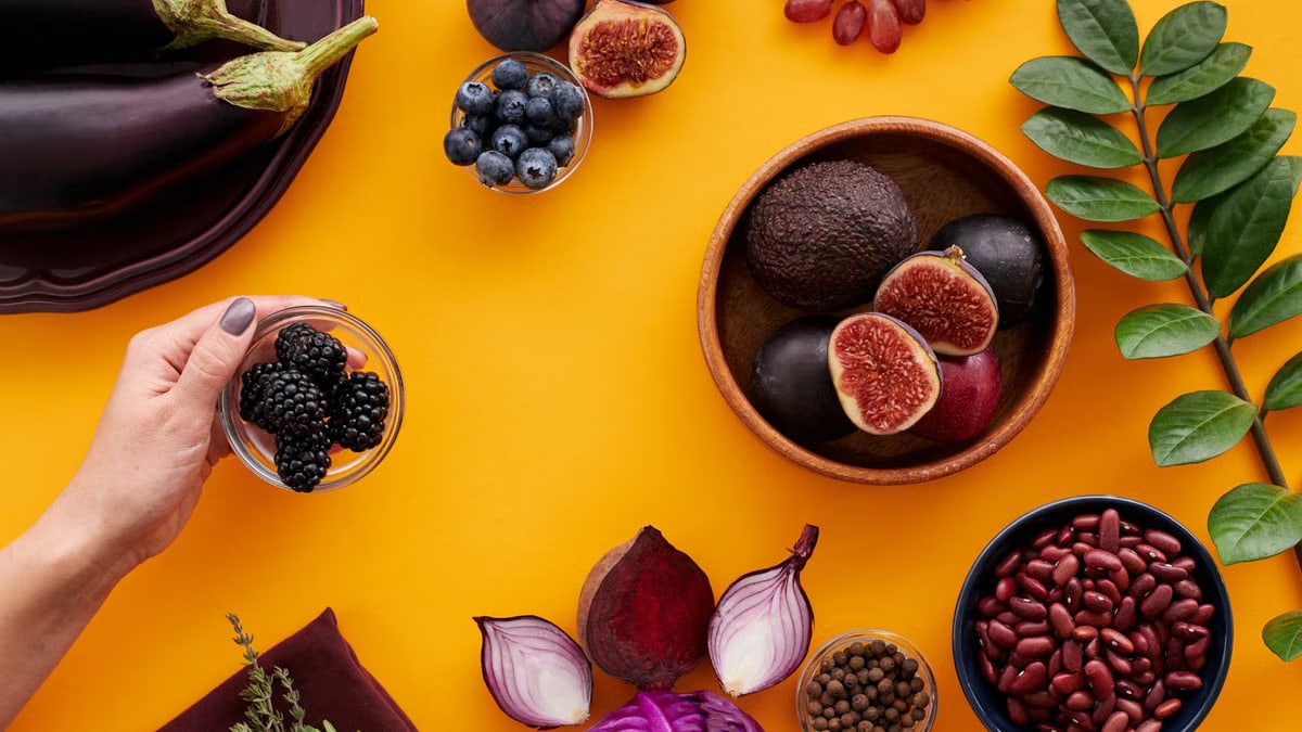 Colorful assortment of fruits and vegetables on a yellow backdrop, highlighting healthy eating.