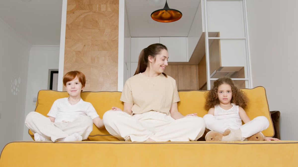A joyful family sitting together on a yellow sofa, showcasing a comfortable and relaxed atmosphere at home.